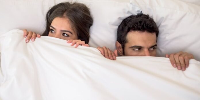 portrait-of-a-scared-couple-in-bed-with-man-and-woman-looking-very-anxious.jpg